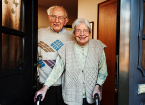 elderly couple walking through a doorway