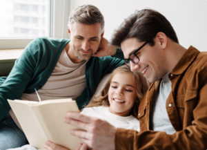 Two dads reading to daughter