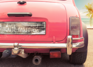 Red car with a license plate that says "Just Married"