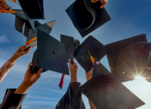hands holding up graduation caps